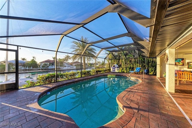 view of swimming pool featuring a water view, glass enclosure, and a patio area