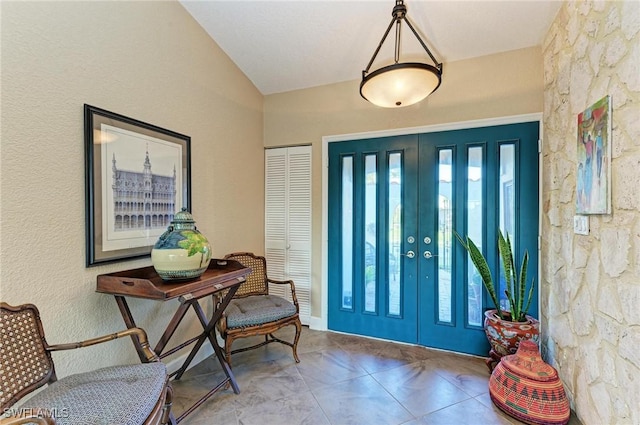 tiled foyer entrance with french doors and vaulted ceiling