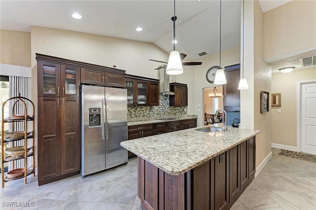 kitchen with light stone countertops, sink, tasteful backsplash, stainless steel fridge, and pendant lighting