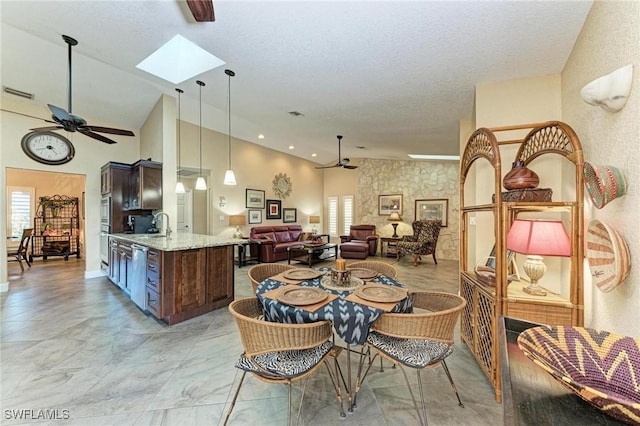 dining room with a skylight, ceiling fan, a healthy amount of sunlight, and a textured ceiling