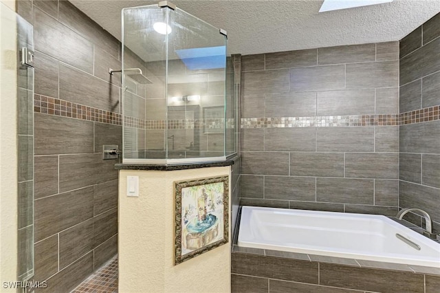 bathroom featuring shower with separate bathtub, a textured ceiling, a skylight, and tile walls