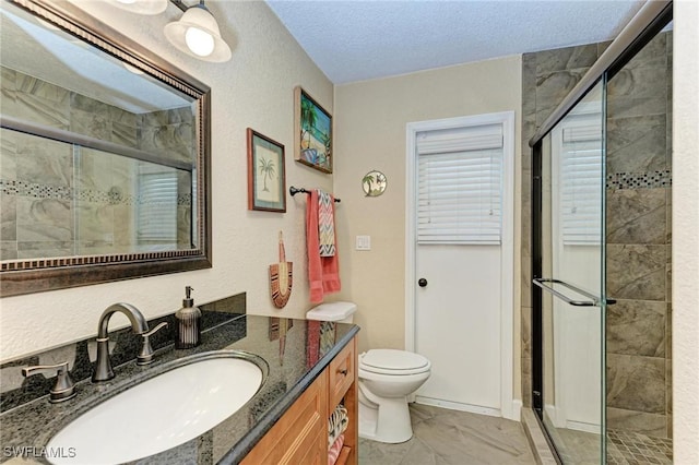 bathroom with walk in shower, vanity, a textured ceiling, and toilet