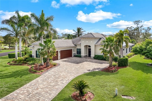 mediterranean / spanish-style home featuring a garage and a front lawn