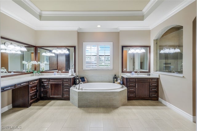 bathroom featuring a relaxing tiled tub, ornamental molding, and vanity