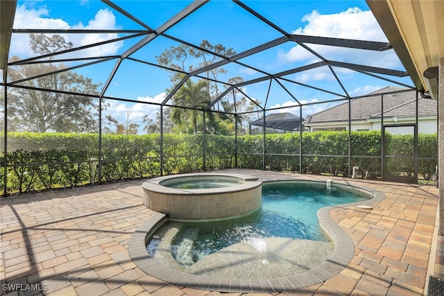 view of swimming pool with glass enclosure, an in ground hot tub, and a patio