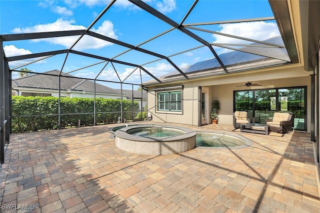 view of patio / terrace featuring an outdoor living space, ceiling fan, a lanai, and an in ground hot tub