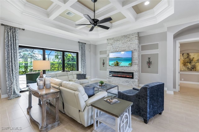 living room with a stone fireplace, ceiling fan, crown molding, and coffered ceiling