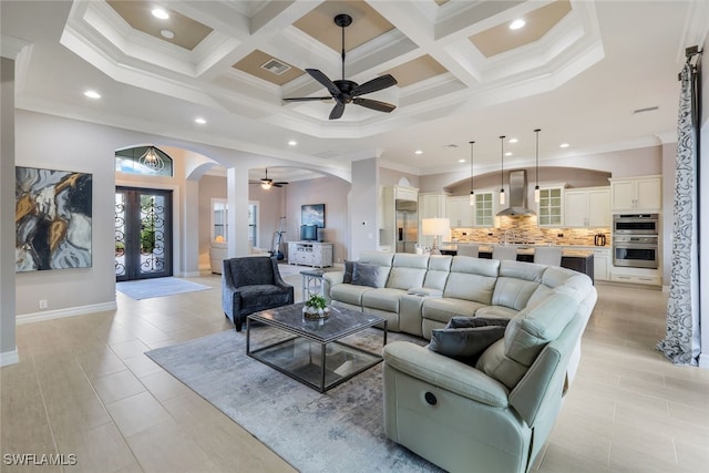 tiled living room with french doors, beamed ceiling, coffered ceiling, and ornamental molding