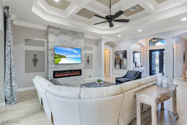 living room with beamed ceiling, crown molding, coffered ceiling, and a stone fireplace