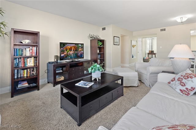 living room featuring carpet, visible vents, and baseboards