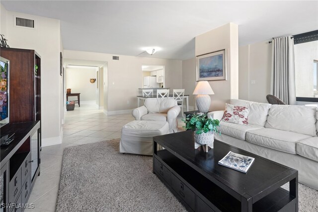 living room with visible vents, baseboards, and light tile patterned floors