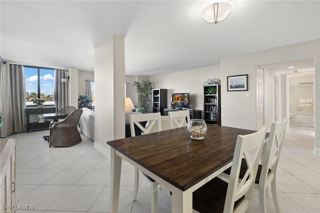 dining room with light tile patterned floors and a wall of windows