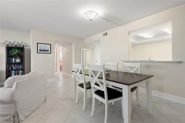 dining space with light tile patterned floors, visible vents, and baseboards