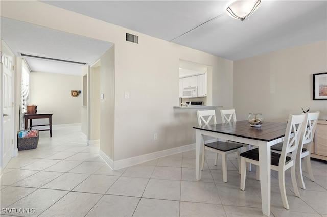 dining area with visible vents, baseboards, and light tile patterned floors