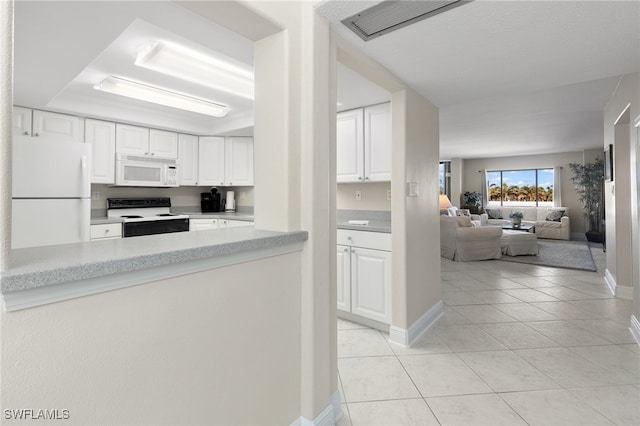 kitchen with light tile patterned floors, white appliances, white cabinetry, open floor plan, and light countertops