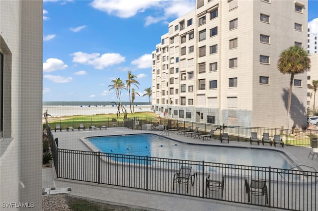 view of pool featuring a patio area and a water view