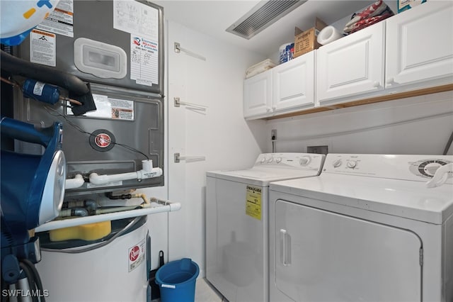 clothes washing area with cabinets, separate washer and dryer, and heating unit