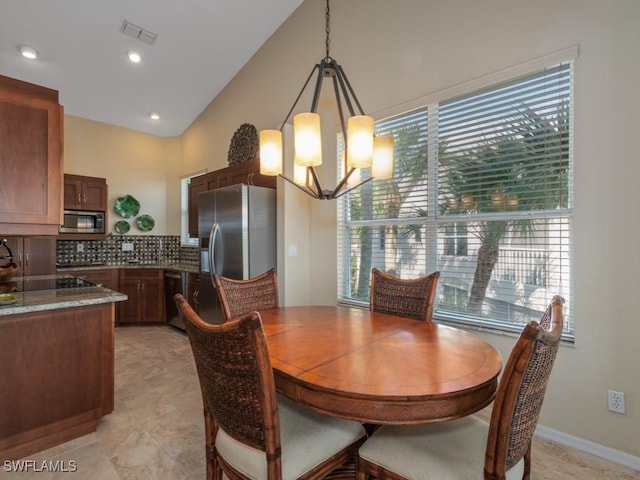 dining space featuring vaulted ceiling, an inviting chandelier, and a wealth of natural light