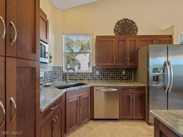 kitchen with tasteful backsplash, light stone countertops, sink, and stainless steel appliances