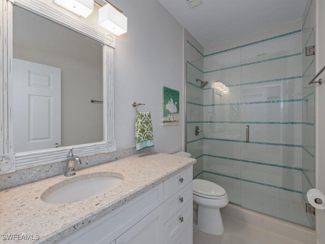 bathroom featuring vanity, toilet, and a shower with shower door