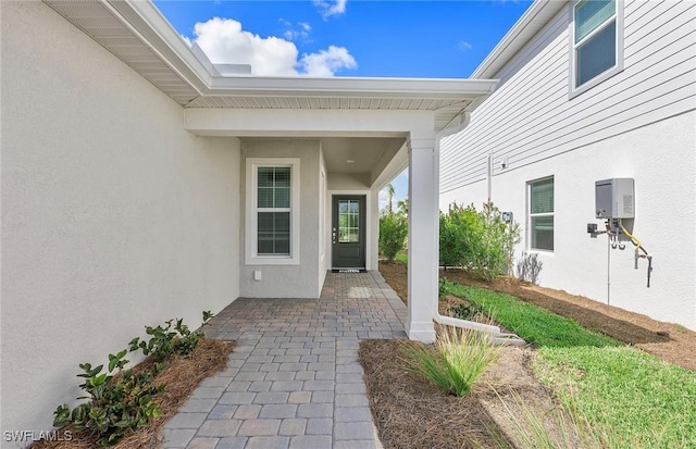 doorway to property featuring a patio and stucco siding