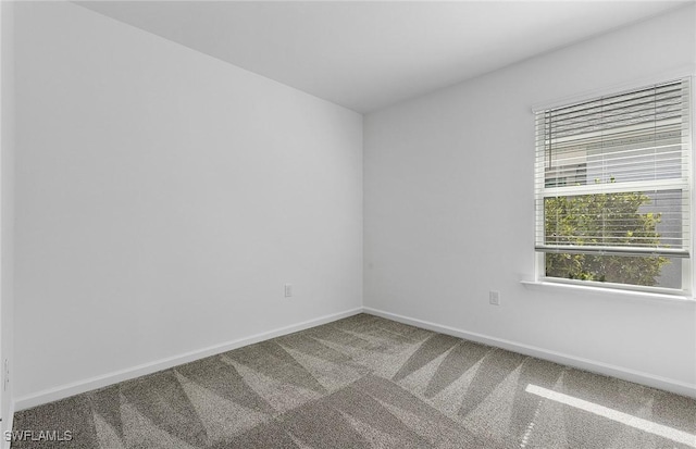 carpeted spare room featuring baseboards