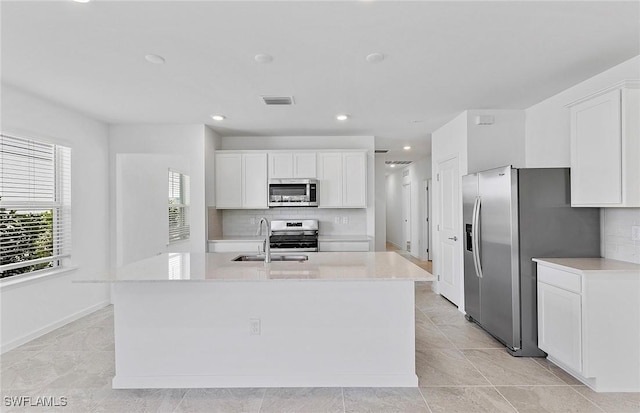 kitchen with visible vents, stainless steel appliances, an island with sink, and white cabinetry