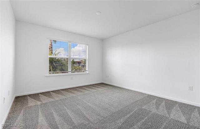 unfurnished room featuring carpet flooring and baseboards