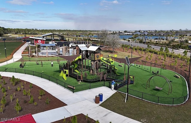 surrounding community with playground community, a yard, and fence