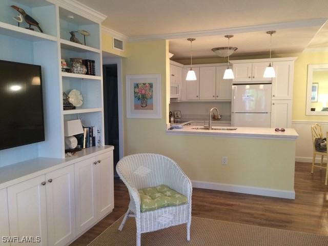 kitchen featuring pendant lighting, white cabinets, white refrigerator, sink, and dark hardwood / wood-style flooring