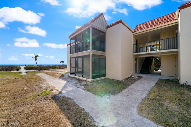 rear view of house featuring a sunroom