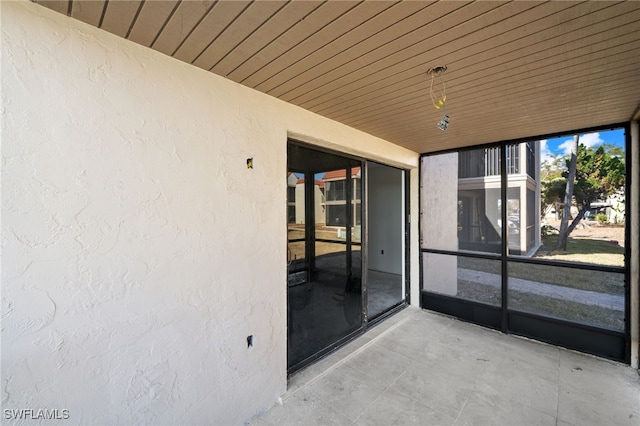 unfurnished sunroom with wood ceiling