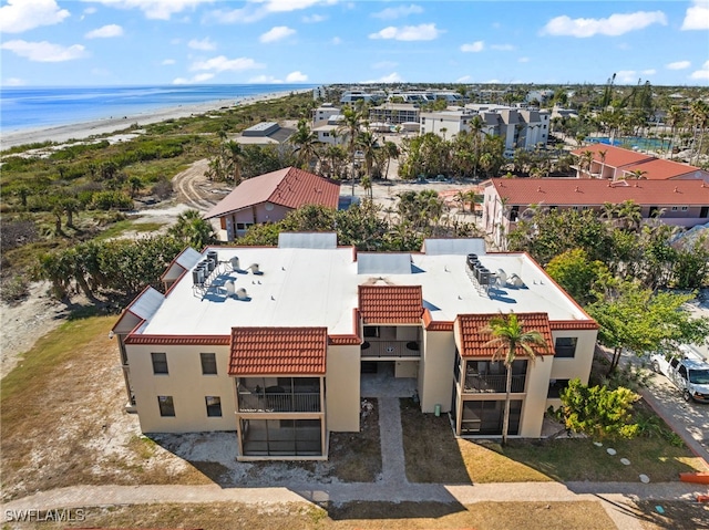 birds eye view of property with a water view and a view of the beach