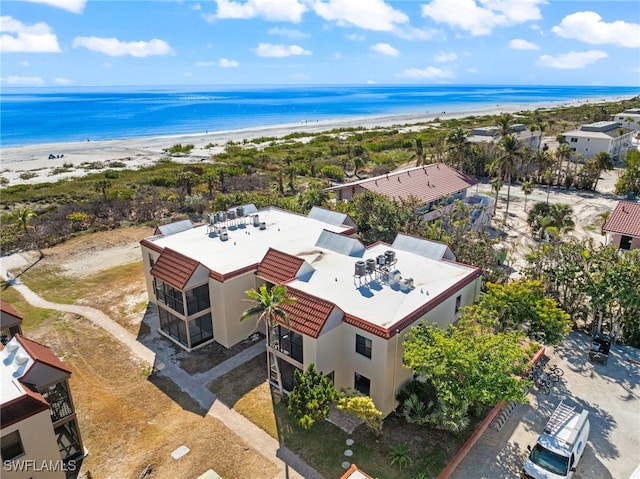 aerial view with a water view and a beach view