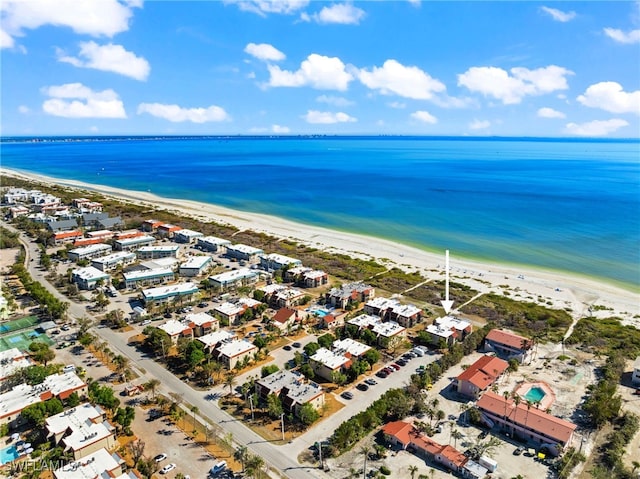 birds eye view of property with a water view and a beach view