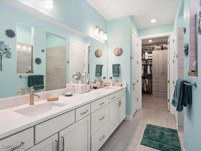 bathroom with a tile shower and vanity