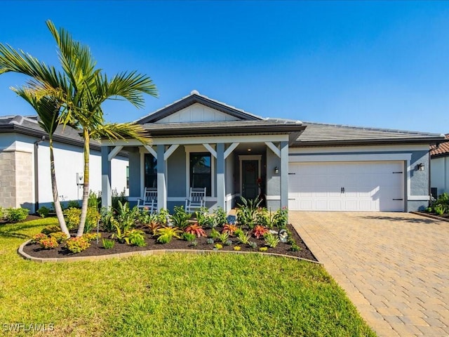 view of front of home with a porch, a garage, and a front yard