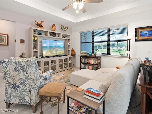 living room featuring hardwood / wood-style floors, a raised ceiling, ceiling fan, and ornamental molding