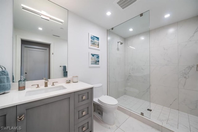 bathroom featuring tile patterned flooring, vanity, toilet, and tiled shower