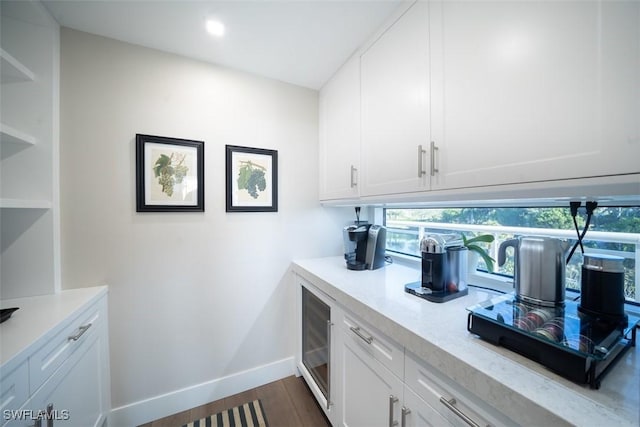 kitchen featuring white cabinetry, light stone counters, and dark hardwood / wood-style floors