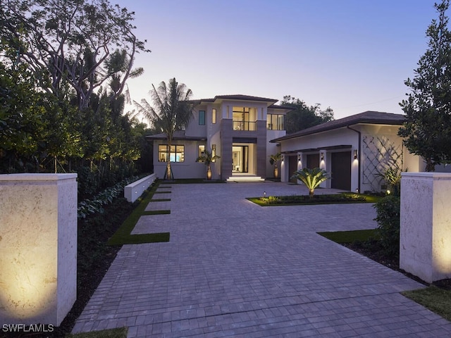 view of front of home with a garage and a balcony