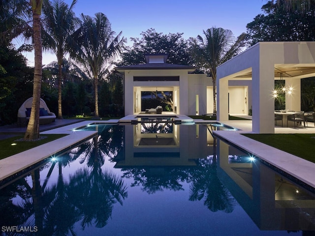 pool at dusk featuring a patio area