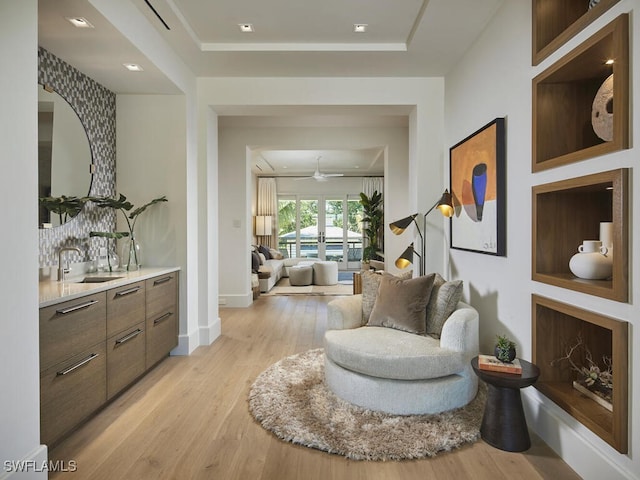 sitting room with french doors, ceiling fan, sink, and light hardwood / wood-style flooring