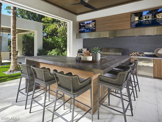 view of patio / terrace featuring grilling area, an outdoor bar, and ceiling fan