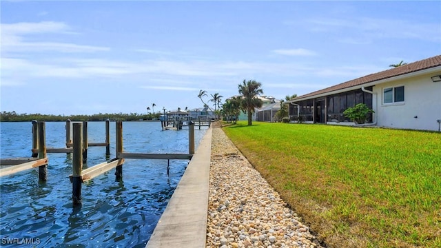 dock area with a lawn and a water view