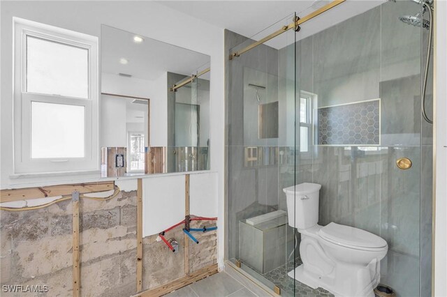 bathroom featuring tile patterned floors, toilet, and an enclosed shower