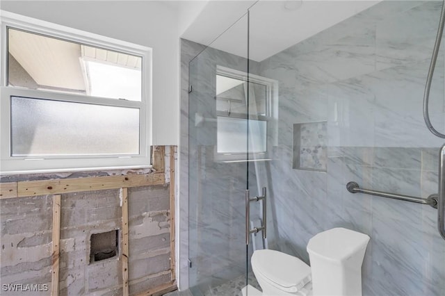 bathroom featuring toilet, an enclosed shower, and tile walls