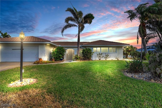 view of front of property with a yard and a garage