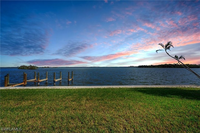 dock area featuring a lawn and a water view