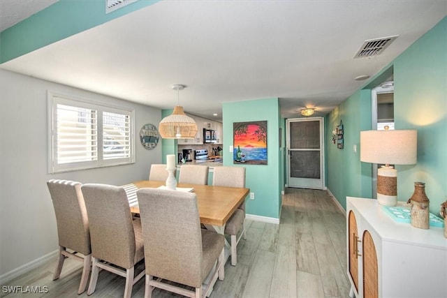 dining space with light hardwood / wood-style floors